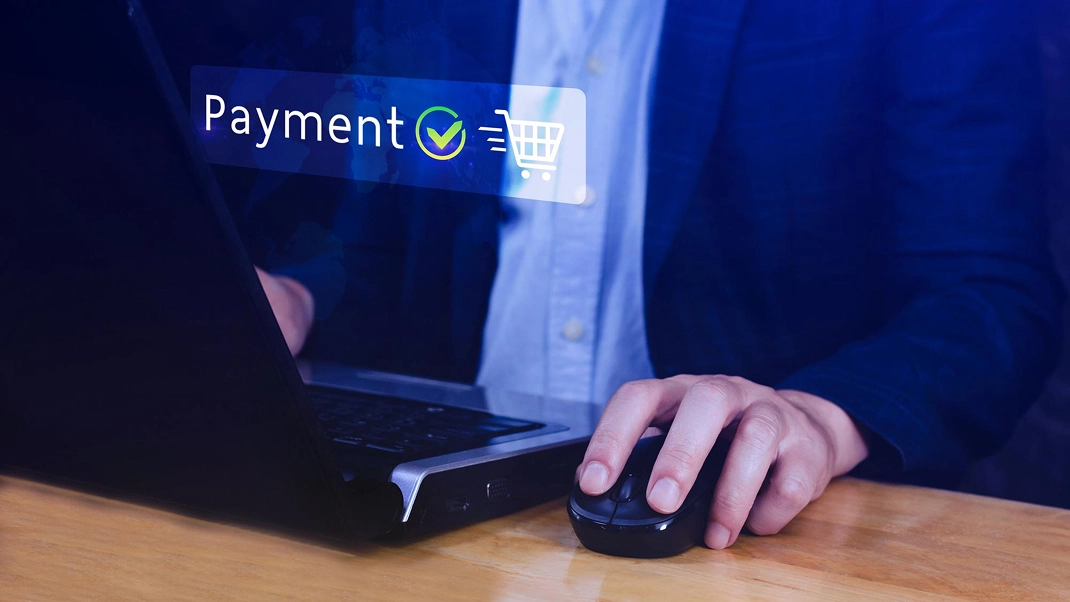 Person using laptop with payment confirmation on screen, symbolizing successful online transaction.